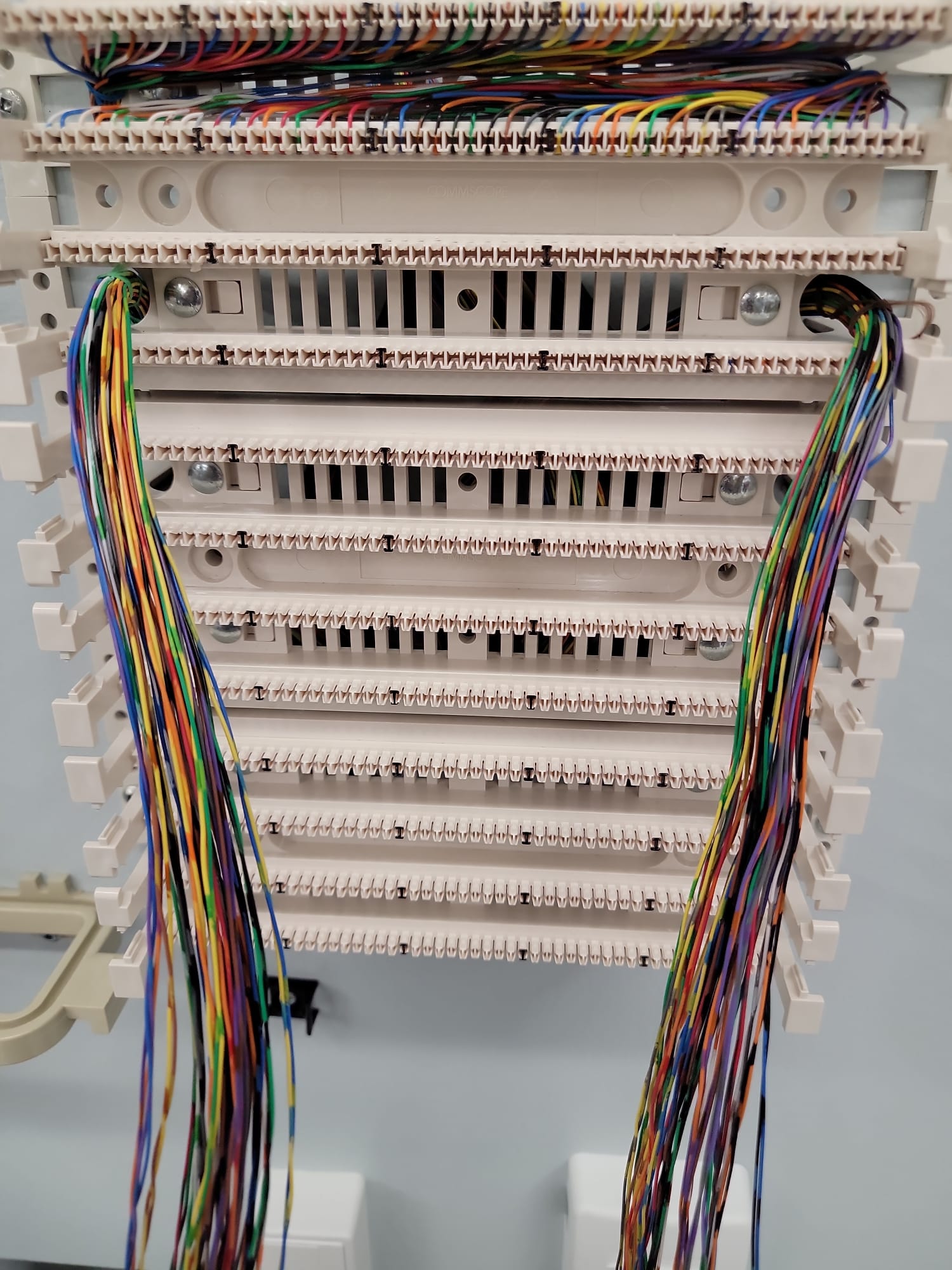 Close-up of 66-block telecom punchdown panel with multi-colored conductors cleanly terminated