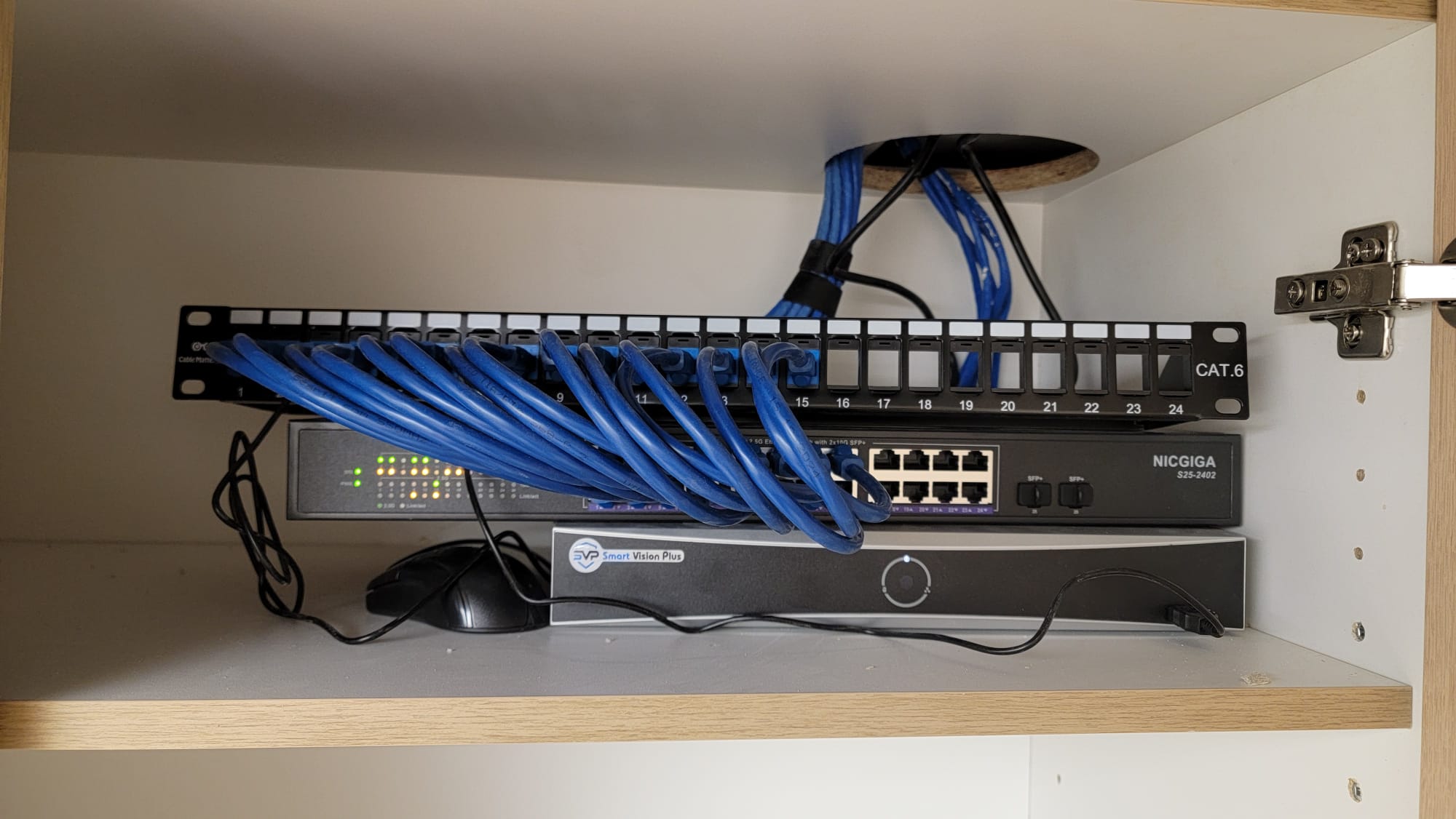 Wall-mount cabinet with patch panel, NICGIGA gigabit switch, and Smart Vision Plus NVR with bundled Cat6 cables